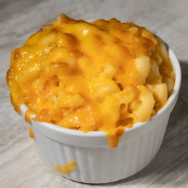 A white ramekin filled with golden-brown baked macaroni and cheese from Who's Got Soul Southern Grill.