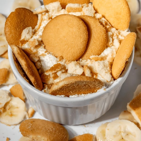 Southern banana pudding with vanilla wafers and fresh banana slices in a white bowl.